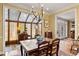 Sunlit dining area with large table, wood furniture, and sunroom offering natural light and scenic views at 4458 Paces Battle Nw, Atlanta, GA 30327