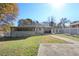 Fenced backyard with a deck, screened porch, mature trees, and sunny skies at 1522 Waltham Se Pl, Atlanta, GA 30316