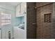 Bathroom with modern glass shower, gray tiled wall, and adjacent laundry at 1522 Waltham Se Pl, Atlanta, GA 30316