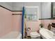 Bright bathroom featuring classic pink tiling with a bathtub, toilet, and a white vanity at 1522 Waltham Se Pl, Atlanta, GA 30316