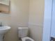 Small half bathroom with pedestal sink and toilet at 10155 Twin Oaks Sw Dr, Covington, GA 30014