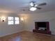 Living room with hardwood floors, brick fireplace and ceiling fan at 10155 Twin Oaks Sw Dr, Covington, GA 30014