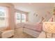 This charming bedroom has a bed with storage, floral wall decor, and lots of natural light at 257 Orwell Dr, Social Circle, GA 30025