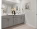 Modern bathroom featuring double vanity, sleek gray cabinets, and a large mirror at 6900 Winchester Pl, Fairburn, GA 30213