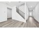 Bright hallway featuring hardwood floors, a staircase with black iron railings, and neutral decor at 6900 Winchester Pl, Fairburn, GA 30213