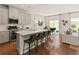 Modern kitchen with stainless steel appliances, island seating, and hardwood floors open to the living room at 6900 Winchester Pl, Fairburn, GA 30213