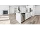 Bright, modern kitchen featuring an island, stainless steel appliances, and an adjacent living area with a fireplace at 6900 Winchester Pl, Fairburn, GA 30213