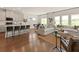 Open concept kitchen and living room with kitchen island, sofas, hardwood floors and many windows at 6900 Winchester Pl, Fairburn, GA 30213