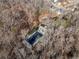 Aerial view of house nestled in wooded lot with paved driveway at 2352 Kelman Pl, Dacula, GA 30019