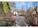 Landscaped backyard featuring a stone pathway leading to a charming shed, surrounded by greenery and trees at 2352 Kelman Pl, Dacula, GA 30019