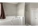 Bathroom featuring a walk-in tub, walk-in shower, and sleek fixtures at 2352 Kelman Pl, Dacula, GA 30019