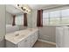 Bathroom featuring double vanity, large mirror, and a window providing natural light at 2352 Kelman Pl, Dacula, GA 30019