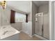 Bathroom featuring a double vanity sink, walk-in shower, and a luxurious walk-in tub at 2352 Kelman Pl, Dacula, GA 30019