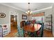 Dining room with stylish light fixture, wood floors, wainscotting, and large windows at 2352 Kelman Pl, Dacula, GA 30019