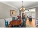 The dining room features a decorative chandelier, hardwood floors, and views of the home office at 2352 Kelman Pl, Dacula, GA 30019