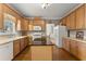 Well-lit kitchen with modern appliances, wooden cabinets, an island, and hardwood floors at 2352 Kelman Pl, Dacula, GA 30019