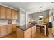 Eat-in kitchen boasts an island with a black countertop, wooden cabinets, and stainless steel appliances at 2352 Kelman Pl, Dacula, GA 30019