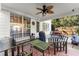 Inviting covered patio with ceiling fan, ideal for outdoor dining and relaxation near large windows and a grill at 2352 Kelman Pl, Dacula, GA 30019
