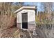 Exterior view of storage shed featuring a brick base, door and surrounding foliage at 2352 Kelman Pl, Dacula, GA 30019