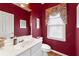 Stylish powder room with a white vanity, framed mirror, and attractive red wall paint at 2818 Colleton Dr, Marietta, GA 30066