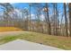 Spacious backyard with a patio, a view of the woods, and a partial view of the fence at 6120 Sparrow Ln, Cumming, GA 30028