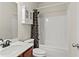 Clean bathroom featuring white cabinet, shower/tub combo, and storage unit at 6120 Sparrow Ln, Cumming, GA 30028