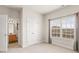 Bright bedroom featuring large window and neutral carpet at 6120 Sparrow Ln, Cumming, GA 30028