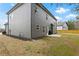 Home exterior featuring gray siding and a well-maintained backyard with a grill at 6120 Sparrow Ln, Cumming, GA 30028