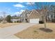 Beautiful two-story home with a mix of siding and brick, a long driveway and a well-maintained lawn under a blue sky at 6120 Sparrow Ln, Cumming, GA 30028