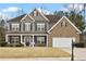 Charming two-story home featuring a mix of siding and brick, complemented by a well-manicured front yard and covered front porch at 6120 Sparrow Ln, Cumming, GA 30028