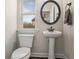 Cozy powder room features a pedestal sink, dark wood floors, and blinds at 6120 Sparrow Ln, Cumming, GA 30028