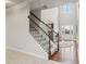 Elegant staircase with carpeted steps, dark wood railings, and iron balusters, leading to a bright and airy upper level at 6120 Sparrow Ln, Cumming, GA 30028