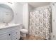 Clean bathroom featuring a vanity with storage, a toilet, and a shower with a decorative curtain at 2804 Parkway Cv, Lithonia, GA 30058