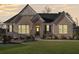 Charming brick home at dusk features a manicured lawn, black shutters, and welcoming front door at 514 Perdue Trl, Canton, GA 30115