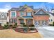 Brick two-story house with a three-car garage and landscaped yard at 1251 Irwin Lake Way, Marietta, GA 30064