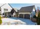 Two-car garage with dark gray doors and stone accents at 5152 Boulder Bluff Way, Suwanee, GA 30024