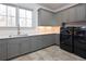 Spacious laundry room with gray cabinets, quartz countertops, and modern washer/dryer at 5152 Boulder Bluff Way, Suwanee, GA 30024