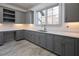 Laundry Room with gray cabinets, quartz countertops, and a built-in desk at 5152 Boulder Bluff Way, Suwanee, GA 30024