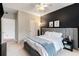 Bright bedroom with ceiling fan, gray upholstered bed, and dark accent wall at 1250 Parkwood Se Cir # 2314, Atlanta, GA 30339