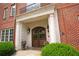 Home entrance features an arched wood door, stone columns, and brick exterior at 351 Washington Ne Ave # 208, Marietta, GA 30060