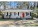Brick ranch house with red front door, landscaping, and a spacious yard at 3212 Ward Sw Dr, Atlanta, GA 30354