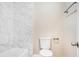Clean bathroom with white toilet and bathtub, marble tile shower surround at 5063 S Woodbridge Trl, Stone Mountain, GA 30088