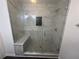 Large walk-in shower with gray marble tile and built-in seat at 2655 Brandenberry Dr, Decatur, GA 30034