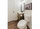 A compact powder room with rustic-style vanity, toilet, and modern lighting at 147 Bowen Sw Cir, Atlanta, GA 30315
