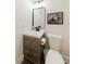 A powder room featuring a rustic vanity, toilet, framed wall art, and wood floors at 147 Bowen Sw Cir, Atlanta, GA 30315