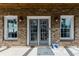 Charming brick-clad front porch with outdoor lighting and a view into the home at 147 Bowen Sw Cir, Atlanta, GA 30315