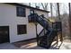 Back exterior of house showing black exterior stairs leading to deck, white siding and black window shutters at 6076 Belle Meade Dr, Villa Rica, GA 30180