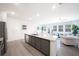 Bright, open kitchen with granite countertops, island sink, stainless steel appliances, and wood floors at 257 Whitetail Cir, Canton, GA 30115