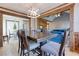Open dining room featuring hardwood floors, wooden beams, an elegant light fixture, and access to living area at 4541 Old Highway 138 Sw, Loganville, GA 30052