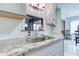 Close-up of a granite countertop with a stainless steel sink and fixtures, complemented by stylish white subway tiles at 4541 Old Highway 138 Sw, Loganville, GA 30052